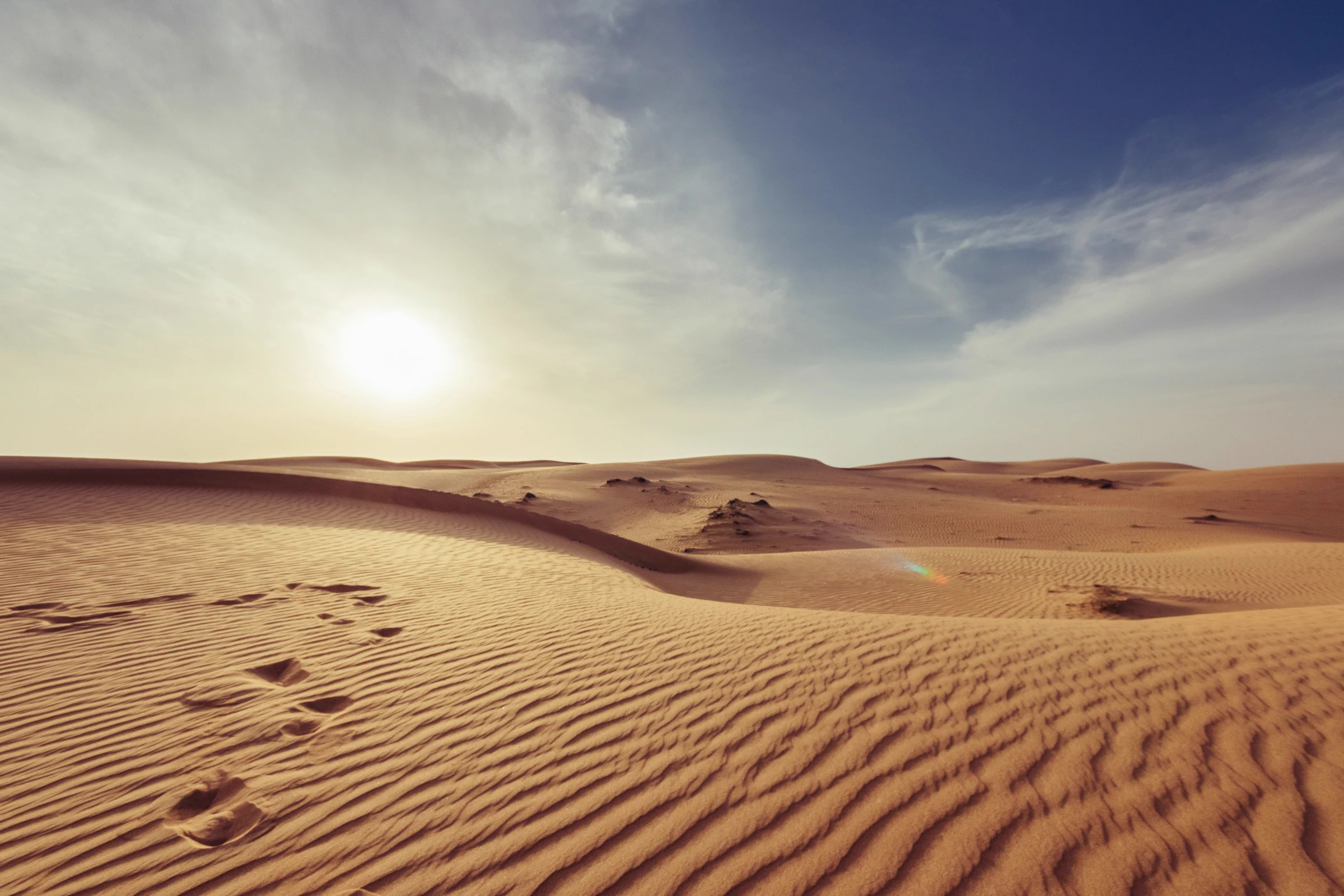 Sculpted golden sand dunes beneath a clear sky